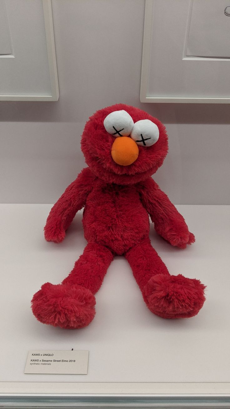 a red stuffed animal sitting on top of a white counter