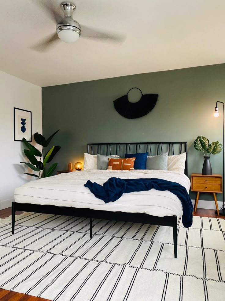 a bedroom with green walls and white bedding