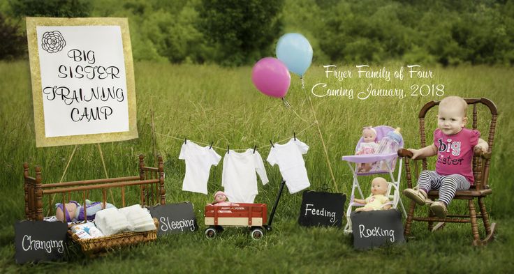 a baby sitting in a chair next to a sign and other items on the grass