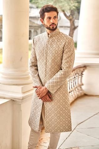 Beige sherwani featuring chikankari floral motif highlighted  with zardozi embroidery. Paired with churidar.
Component: 2
Pattern: Embroidered
Type Of Work: Zardozi
Neckline: Mandarin Collar
Sleeve Type: Straight Full
Fabric: Chikankari, Silk
Color: Beige
Other Details: 
Intricate floral motifs
Zardozi highlights
Front and side slit sherwani
Note: The green bandhgala set worn by the model on the right is not for sale
Occasion: Groom - Aza Fashions Chikankari Sherwani For Men, Indian Wedding Clothes For Men, Sherwani For Men Wedding, Wedding Kurta For Men, Marathi Wedding, Haldi Outfits, Groom Dress Men, Wedding Outfits For Groom, Jayanti Reddy