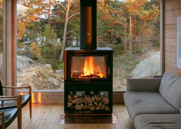 a living room filled with furniture and a fire place in front of a large window