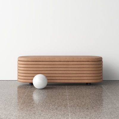 a white ball sitting on top of a floor next to a wooden bench and wall