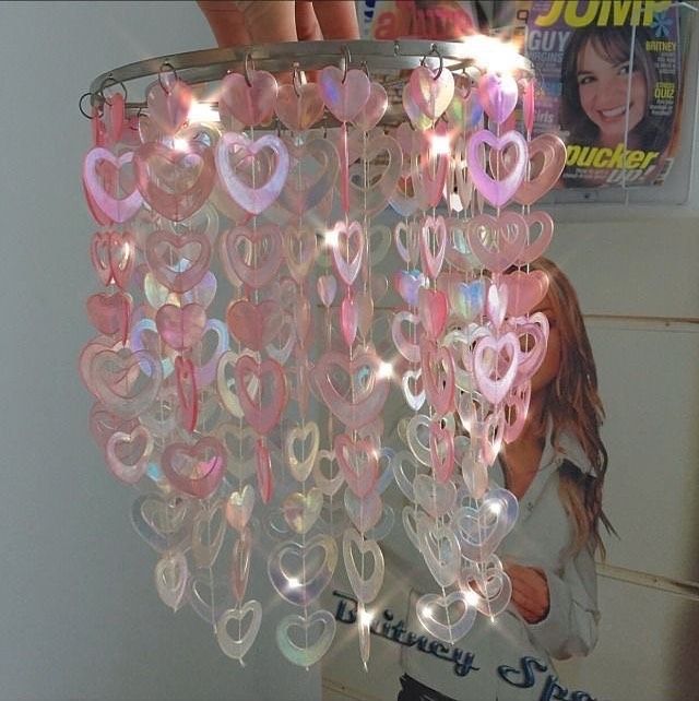 a chandelier made out of plastic hearts hanging from the ceiling in front of a magazine