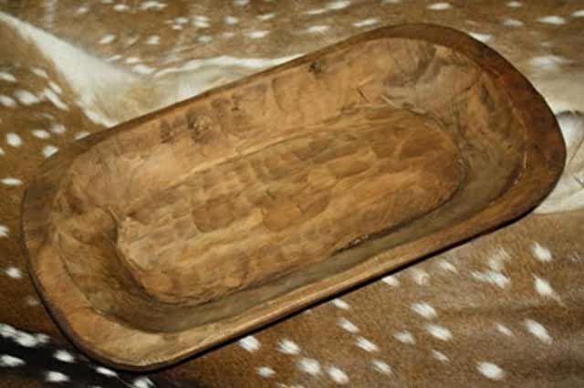 a wooden tray sitting on top of a deer skin blanket