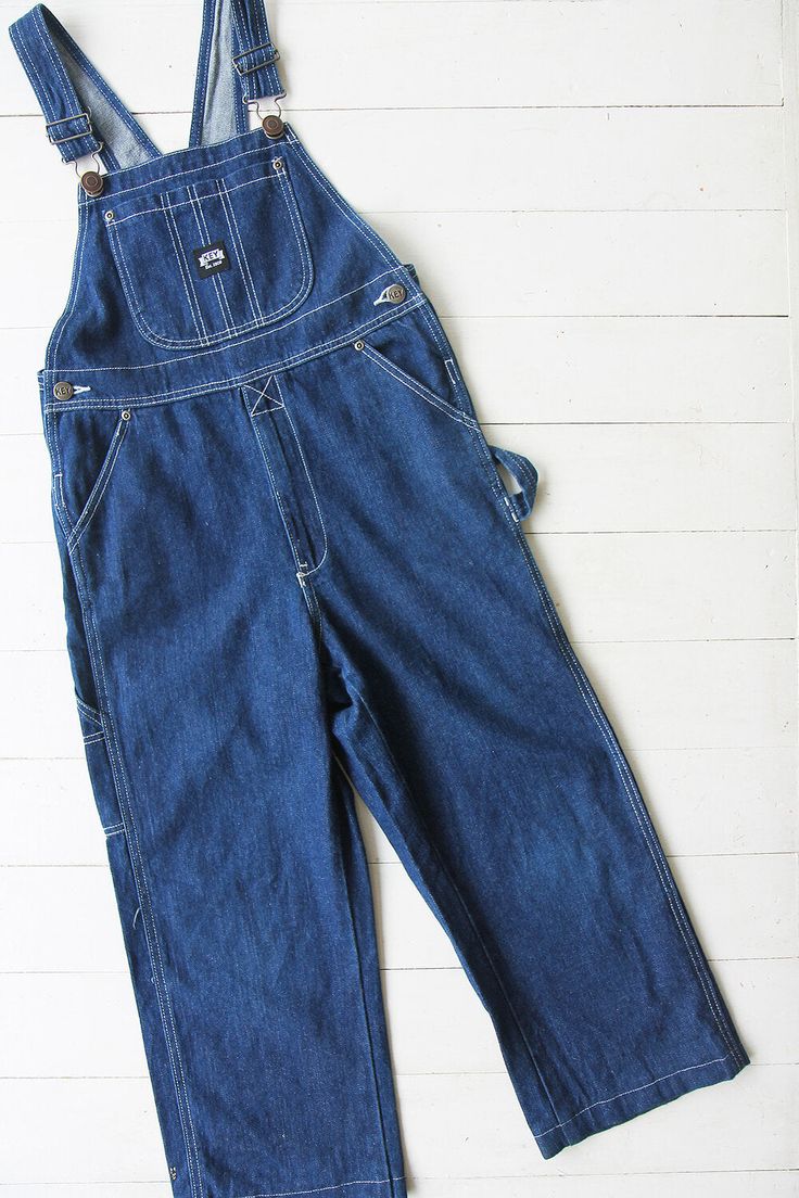 Vintage denim dungarees in blue. Single chest pocket and double waist pockets front and back. Tapered leg. UK 6 / EUR 34 Measurements - 30"(76cm) waist - 32"(81cm) hips - 21"(53cm) inner leg. Material - Denim. Condition - Excellent. Handpicked, repaired and ready to wear. This is an original vintage item, not new and minor signs of wear & age are expected, we will highlight any major flaws. Model is a UK 8 and is 5'6" tall. Vintage Denim Jeans With Side Pockets, Denim Bib Front Jumpsuit With Pockets, Denim Jumpsuit With Bib Front And Pockets, Utility High Rise Overalls With Pockets, Denim Bib Front Overalls With Pockets, Utility Denim Bib Front Bottoms, Utility Denim Bottoms With Bib Front, Denim Shortalls With Pockets In Dark Wash, Dark Wash Denim Shortalls With Pockets