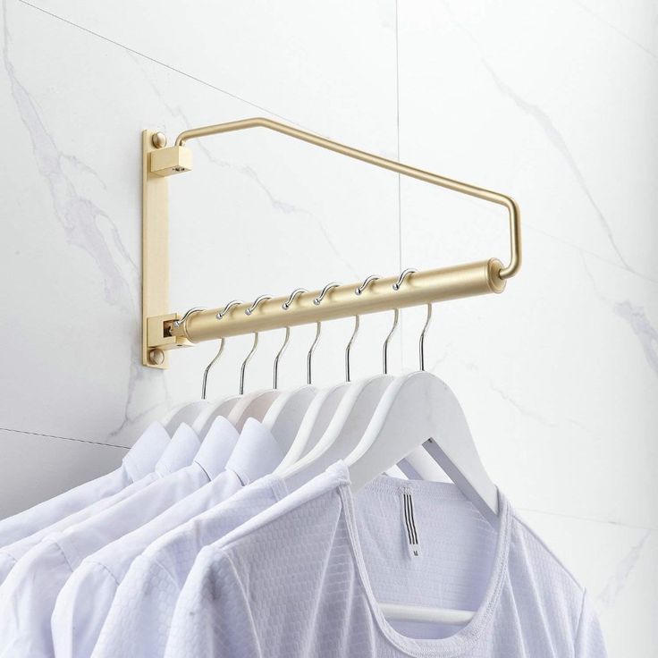 clothes hangers are hanging on the wall next to white shirts