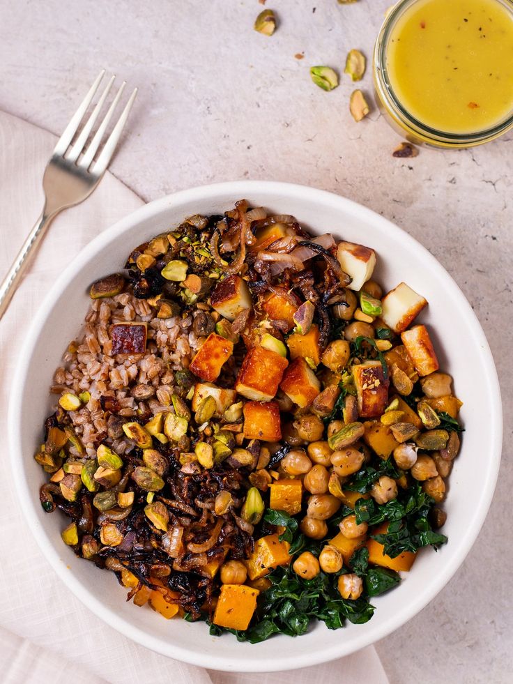 a white bowl filled with food next to a fork