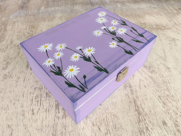 a purple box with daisies painted on it