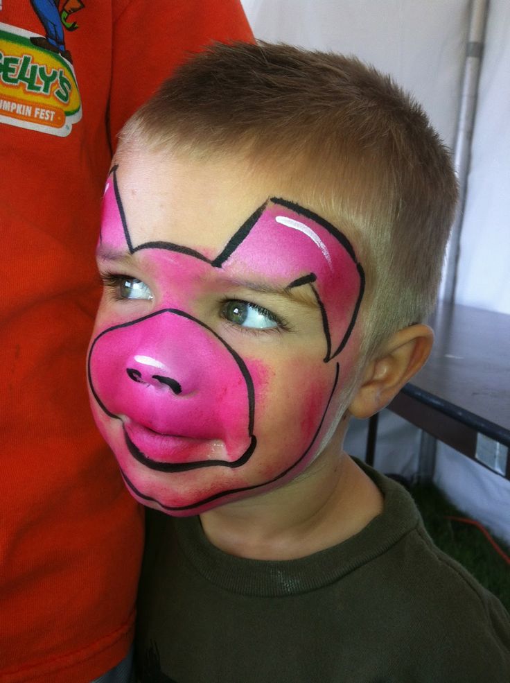 a young boy with his face painted like a pig