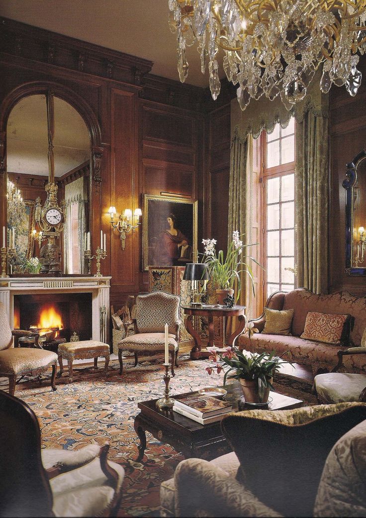 a living room filled with lots of furniture and a chandelier hanging from the ceiling