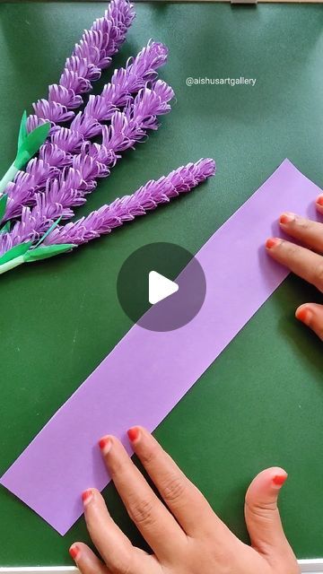 someone is making a flower out of paper and glues it on the table with their hands