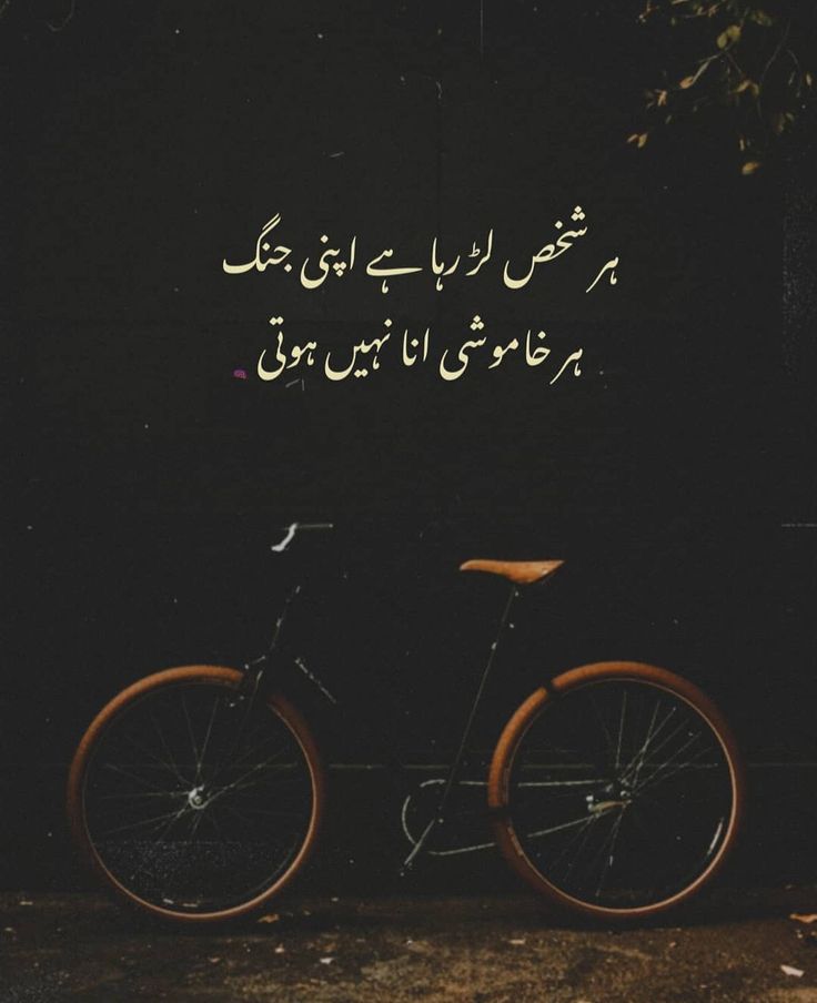 a bicycle parked in front of a black wall with an arabic quote on the back