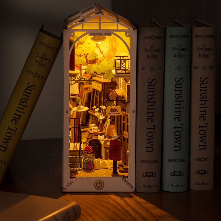 a miniature house made out of books sitting on a table next to a book case