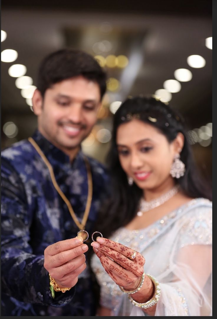 the bride and groom are holding their wedding rings