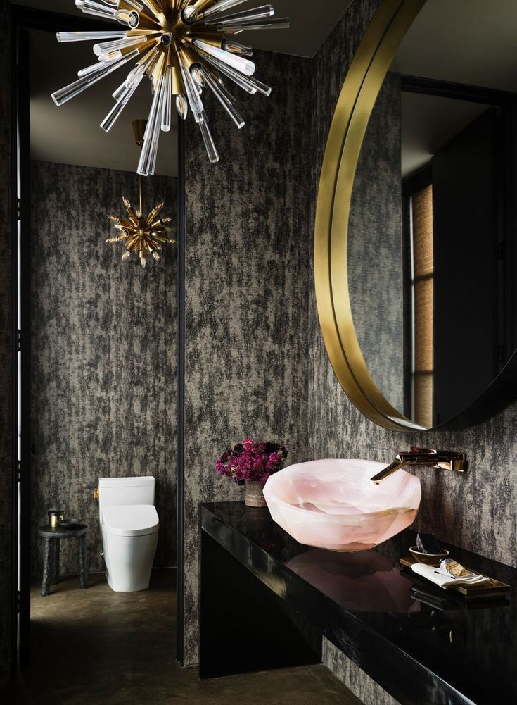 a bathroom with a sink, mirror and chandelier in the middle of it