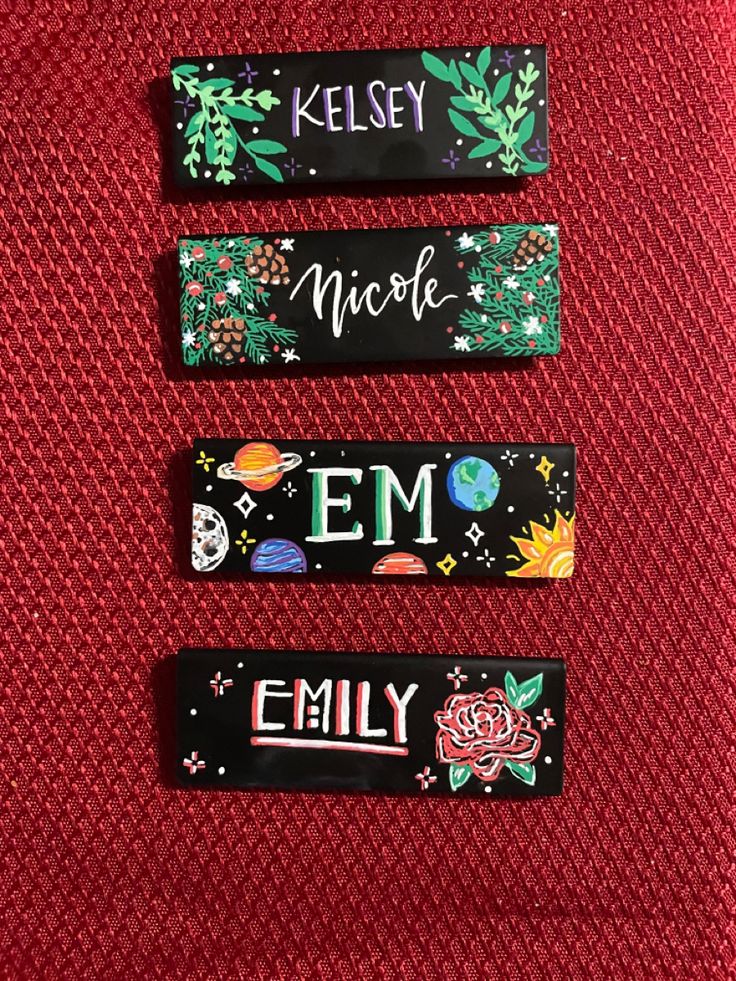 three magnets with words on them sitting on a piece of red material that says kelsey, nicole, emo, and emily