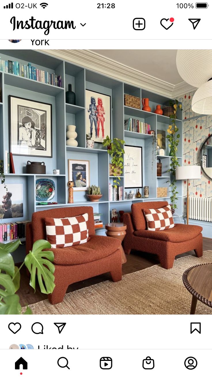 a living room filled with furniture and bookshelves covered in pictures on the walls