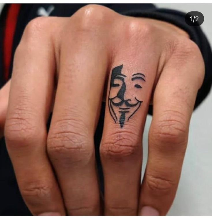 a person with a face tattoo on their finger