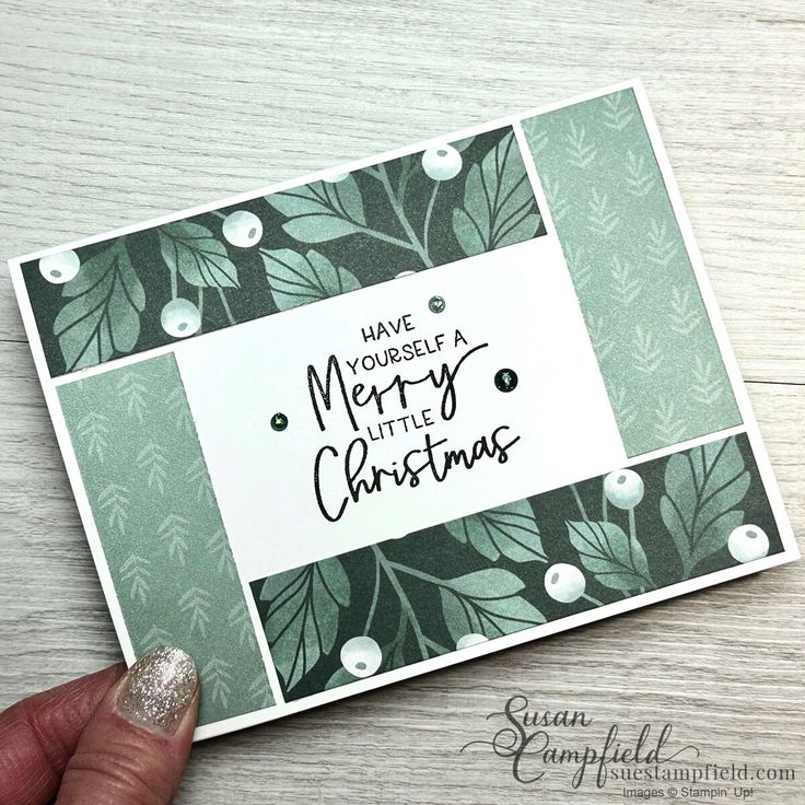 someone holding up a christmas card with the words have yourself a merry little christmas on it