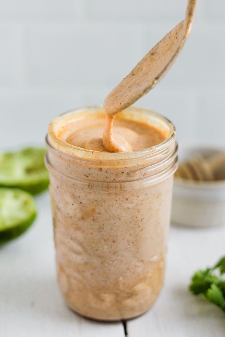 a jar filled with peanut butter and topped with a wooden spoon