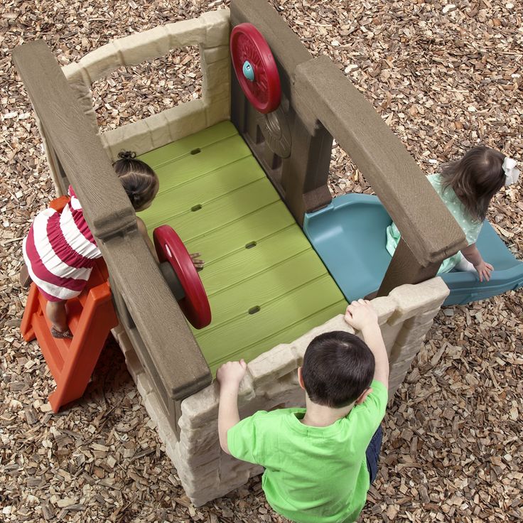 two children playing in a wooden play structure