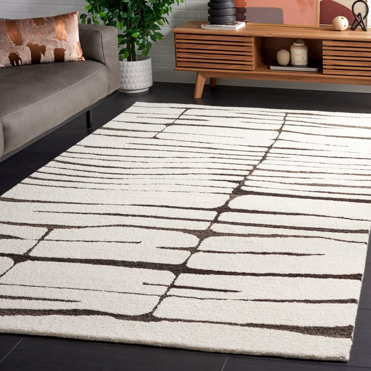 a white rug with brown lines on it in a room next to a couch and coffee table