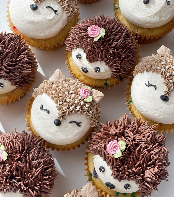 hedgehog cupcakes with frosting and flowers on them