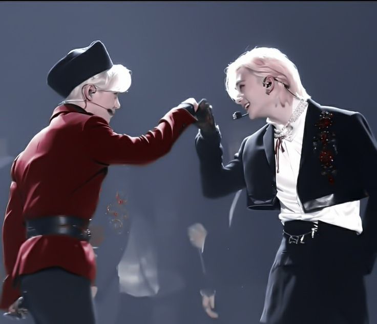 two people dressed in black and red are dancing with one holding the other's hand