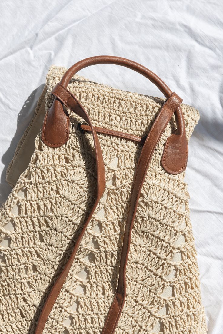 a crocheted purse sitting on top of a white sheet