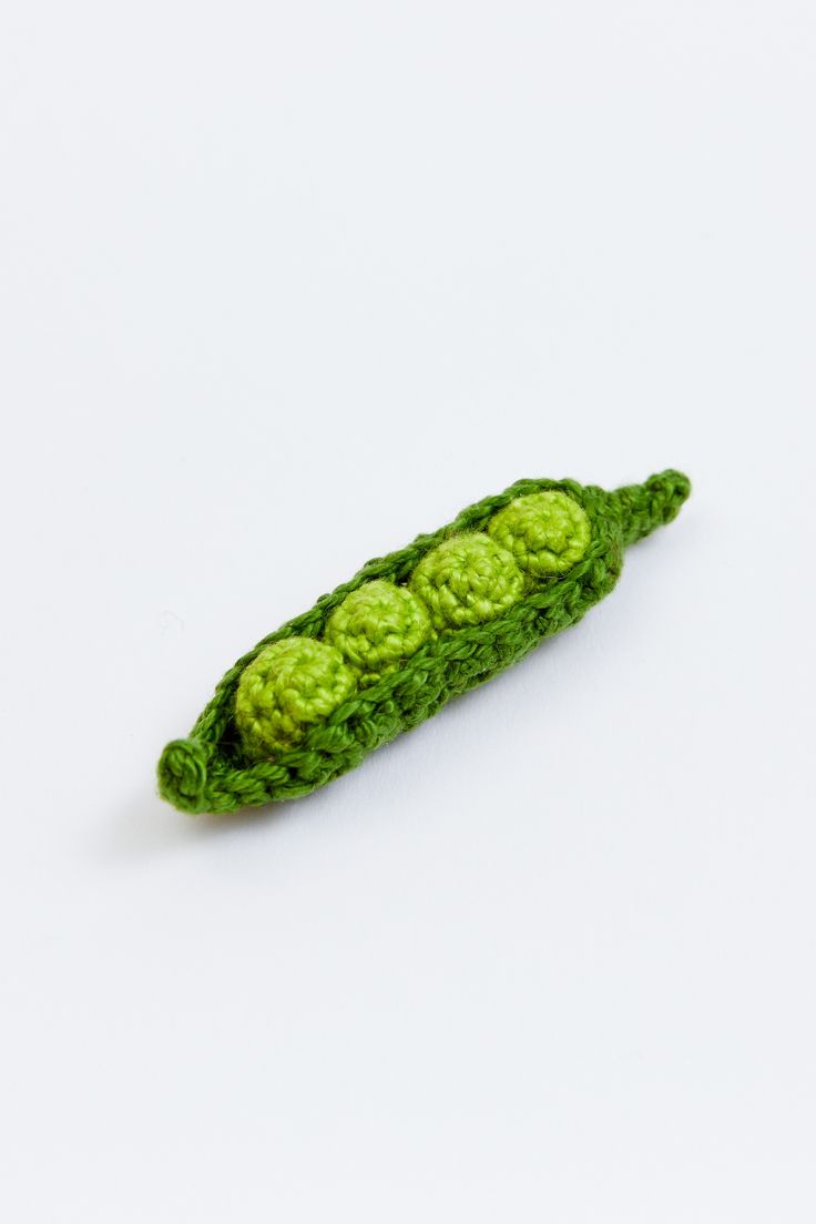 a crocheted pea pod on a white surface