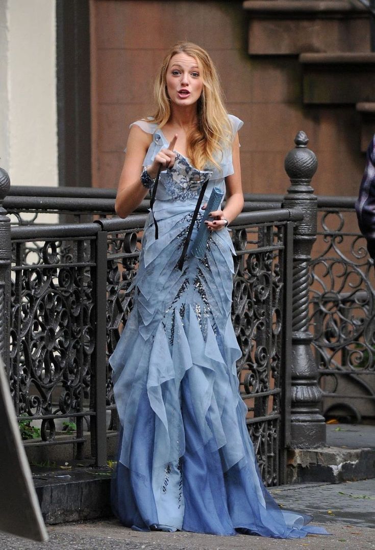 a woman in a blue dress holding an umbrella