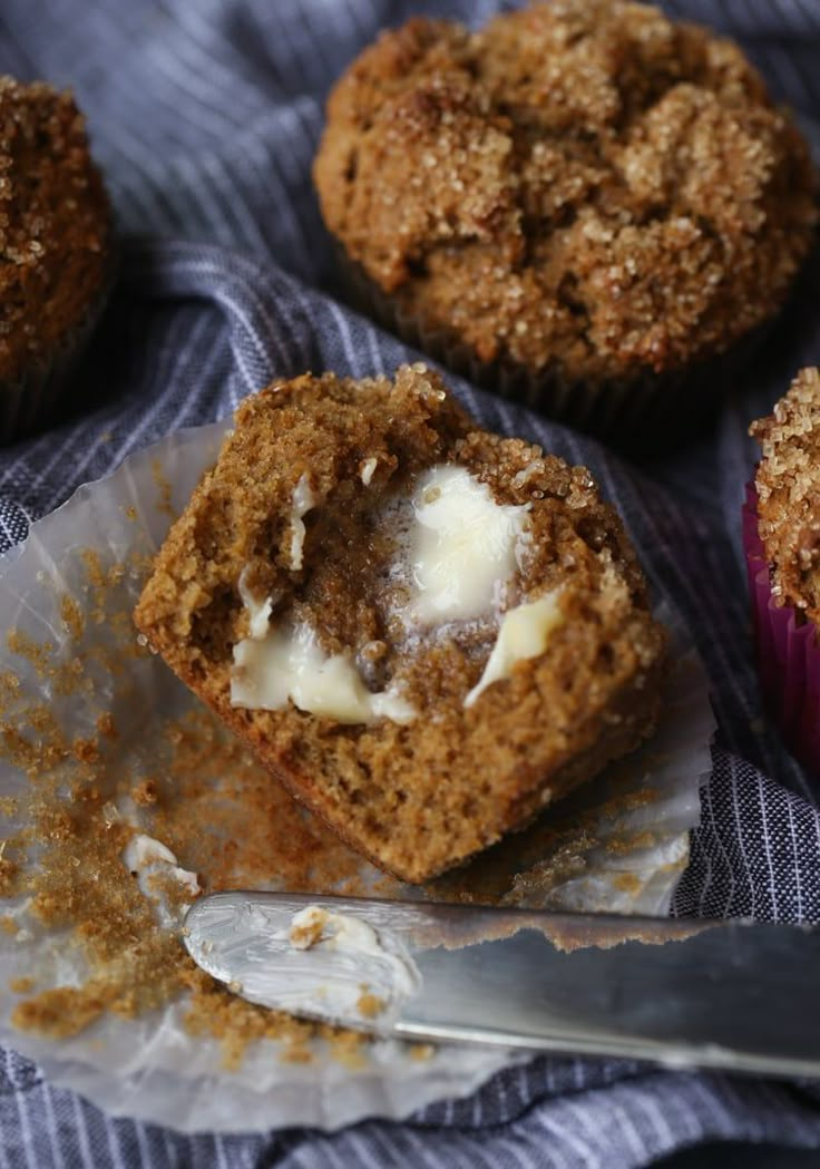 several muffins with white frosting sitting on a cloth