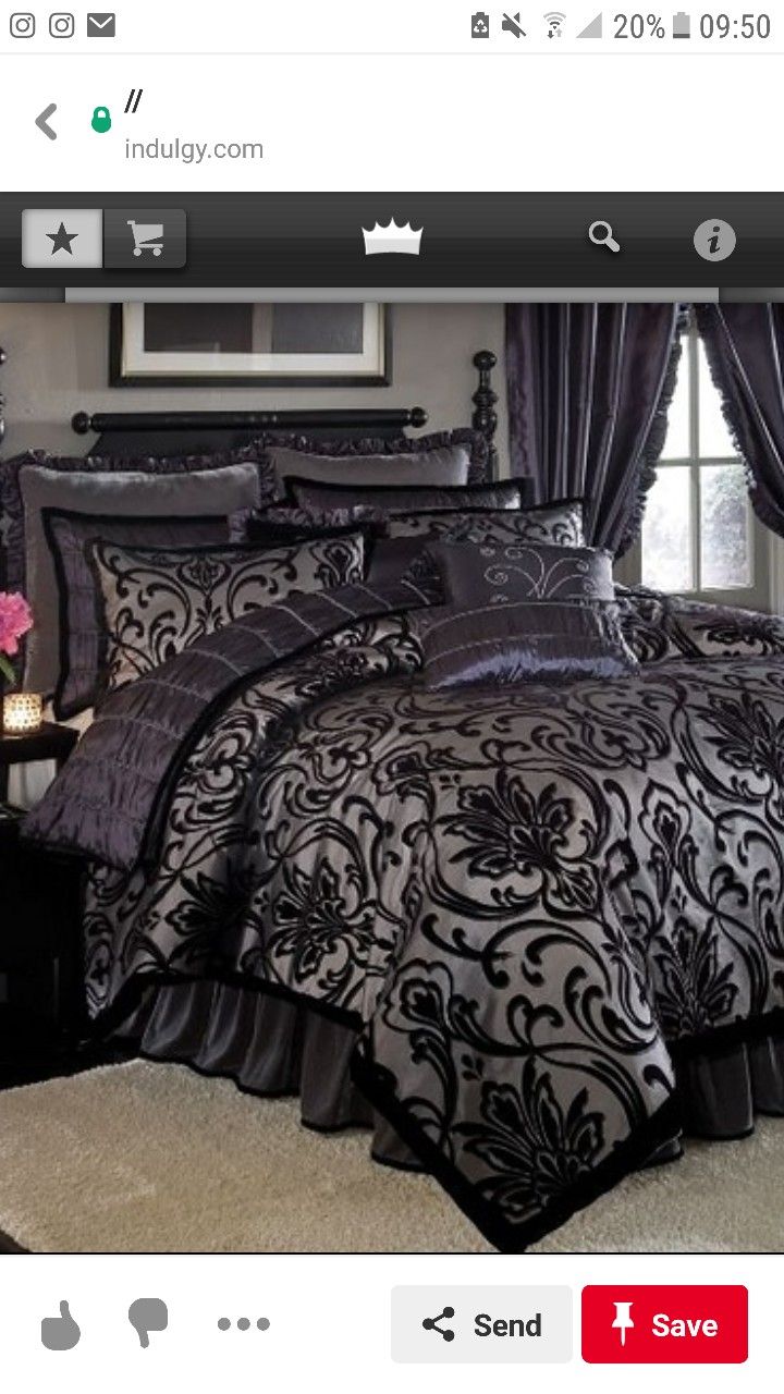 a black and white bed in a bedroom next to a table with flowers on it