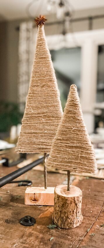 two small christmas trees made out of twine on top of a wooden table next to scissors