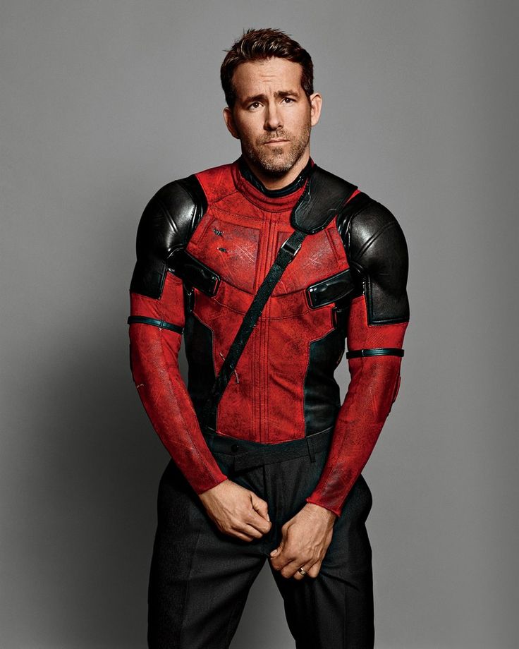 a man in a red and black costume is posing for a photo with his hands on his hips