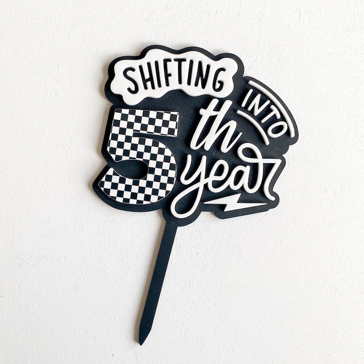 a black and white cake topper that says shifting into the year 5 on it