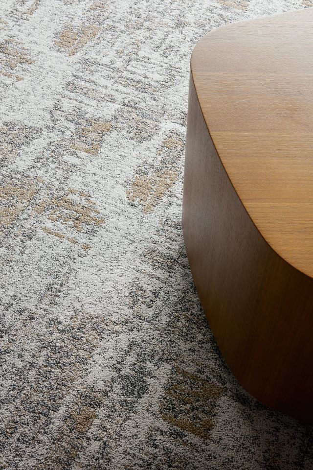 a wooden table sitting on top of a carpeted floor next to a white rug