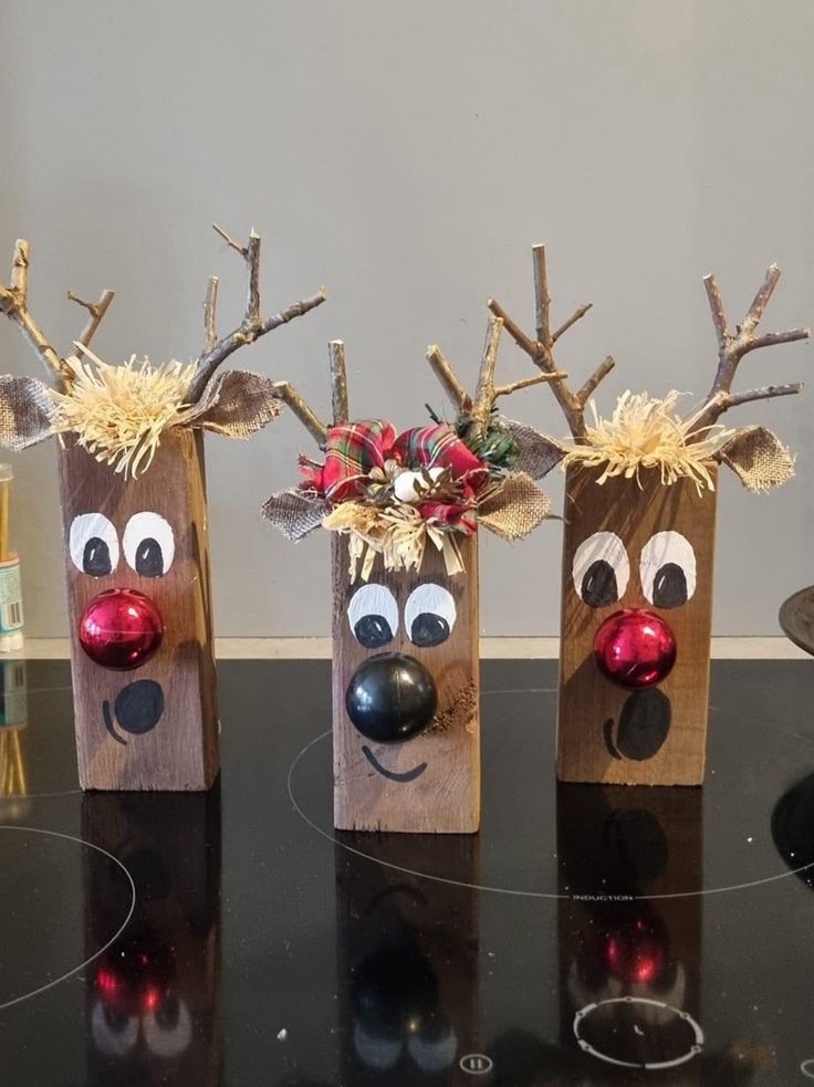 three wooden reindeer head vases sitting on top of a table