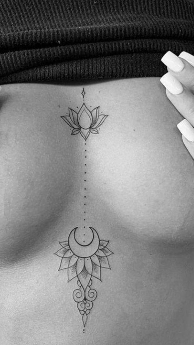 a woman's stomach with a lotus tattoo on the side and an upside down crescent