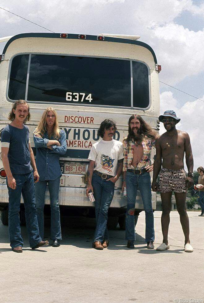 four people standing in front of a bus