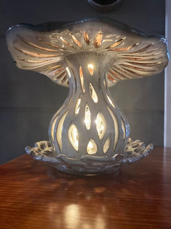 a glass candle holder sitting on top of a wooden table