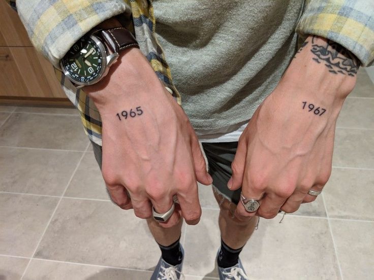 two men with matching tattoos on their hands