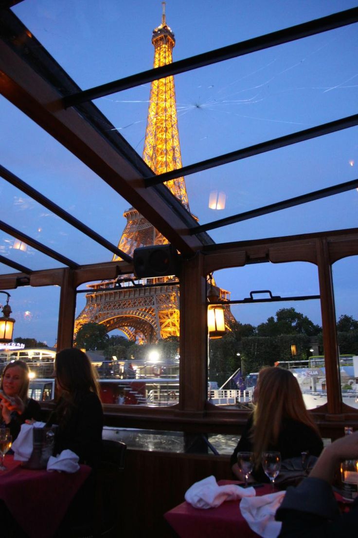 people sitting at tables in front of the eiffel tower