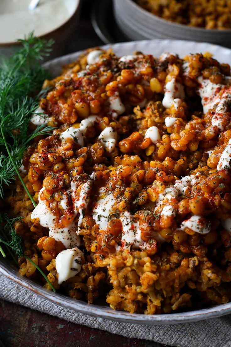 a bowl filled with rice covered in sauce and garnished with parsley