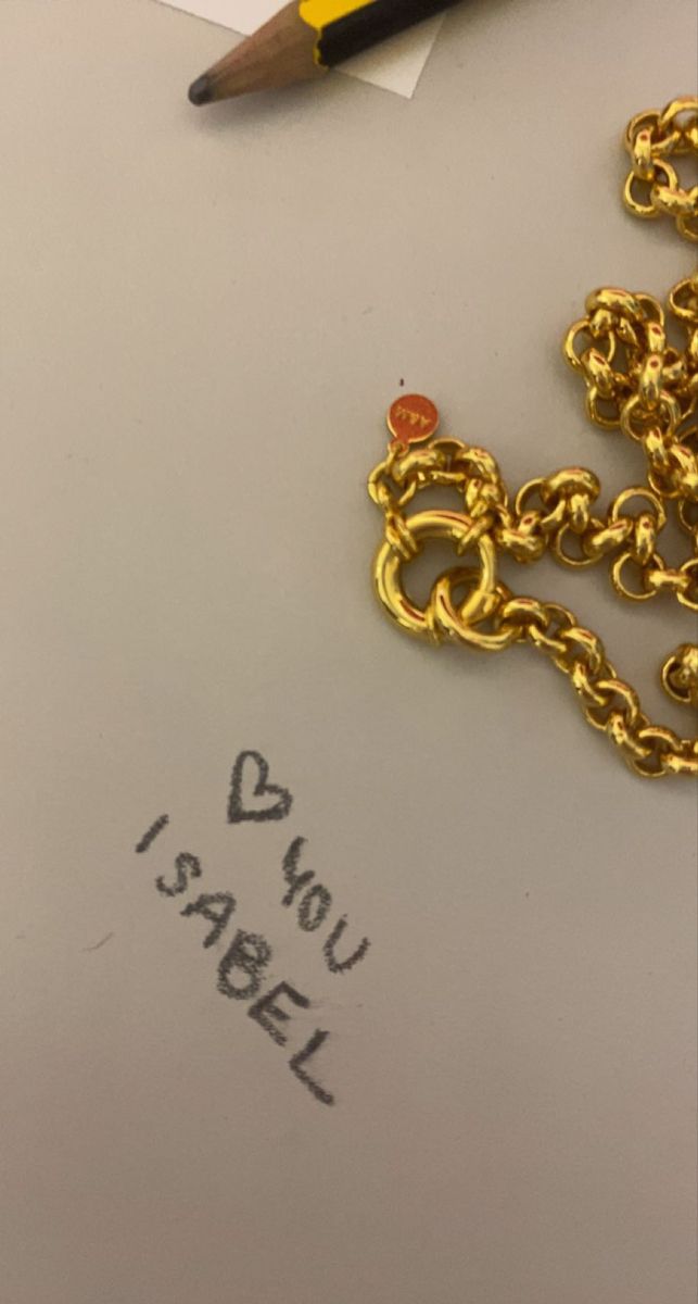 a piece of paper with writing on it next to a pen and a gold chain