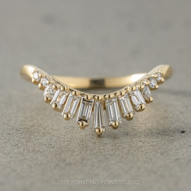 a yellow gold ring with baguettes and diamonds on it's sidestone