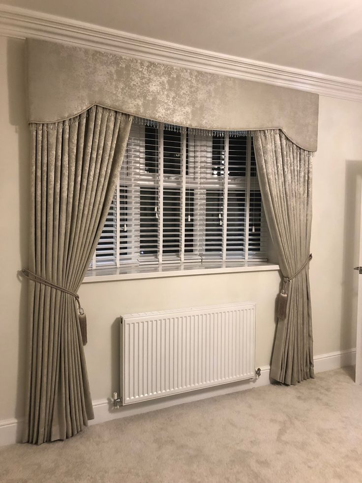 an empty room with a window, radiator and curtains