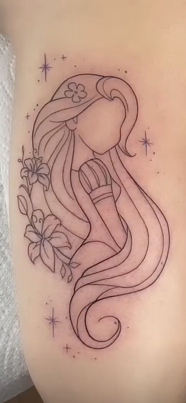 a woman's stomach with an octopus tattoo on her belly and flowers around it