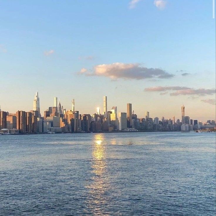 the sun is setting over the city skyline as it reflects in the water on a sunny day