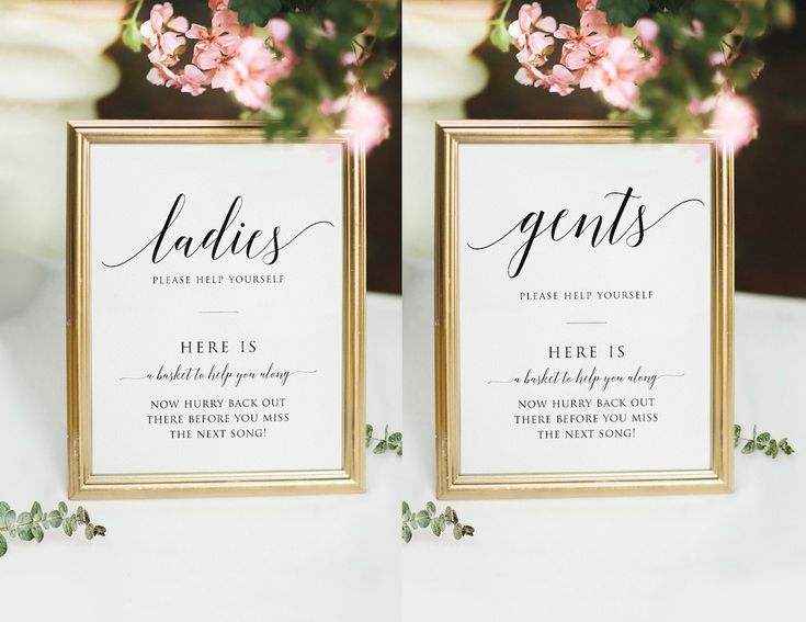 two gold frames with pink flowers and greenery on them are sitting on a table